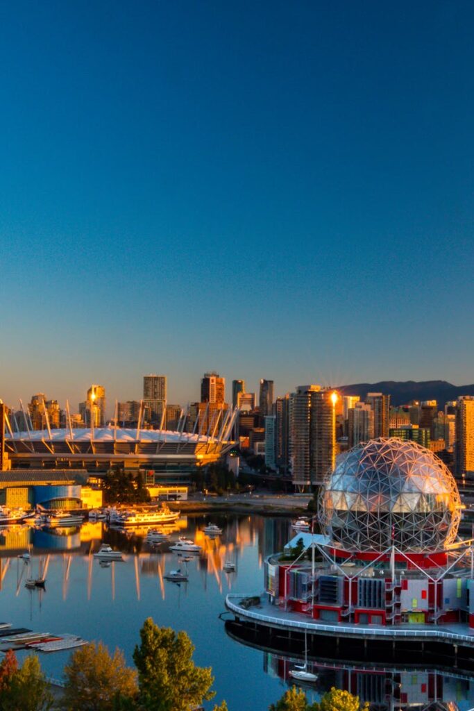 Vibrant sunset view of Vancouver's skyline, featuring Science World and cityscape reflections.